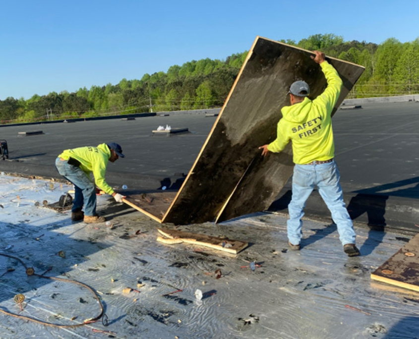 Workers installing new roofing materials