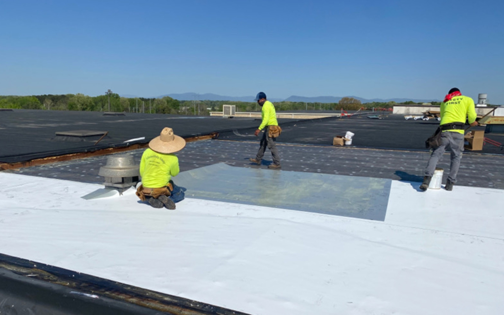 Workers on flat white roof