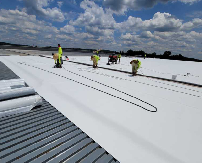 Workers sealing flat roof