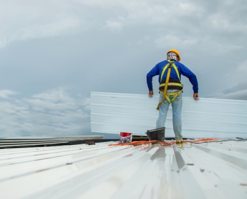 Worker Installing Metal Roof Panels