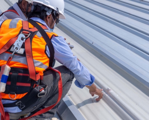 Workers Inspecting Metal Commmercail Roof