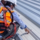 Workers Inspecting Metal Commmercail Roof
