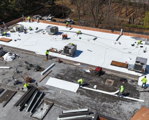 Side Aerial View Of Roofers At Work